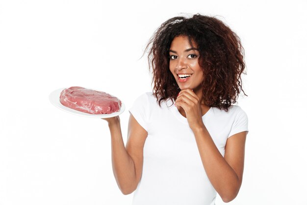 Jeune femme africaine tenant de la viande.