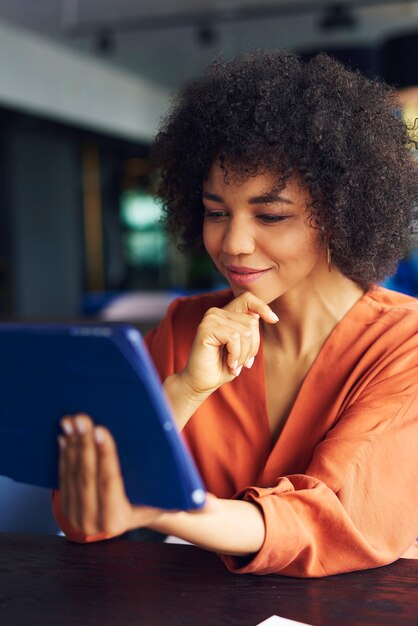 Jeune femme africaine travaillant avec la technologie