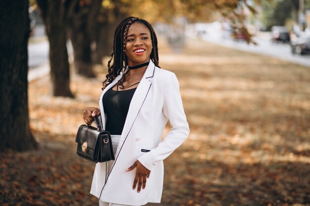 Jeune femme africaine vêtue d'un costume blanc dans le parc