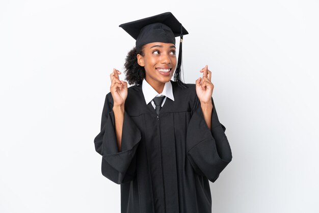 Jeune femme afro-américaine diplômée universitaire isolée sur fond blanc avec les doigts qui se croisent