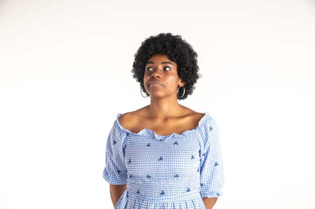 Jeune femme afro-américaine émotionnelle en robe bleue. Expression faciale, concept d'émotions humaines. Réfléchi, rêveur.