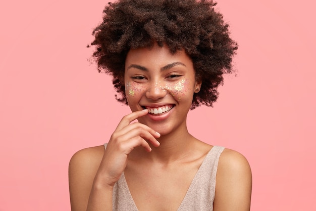 Jeune femme afro-américaine avec des paillettes sur le visage