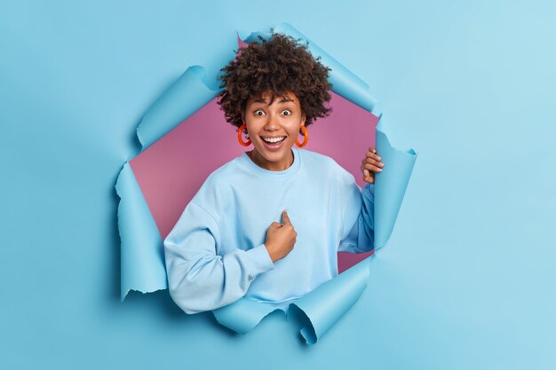 Une jeune femme afro-américaine positive se pointe un large sourire