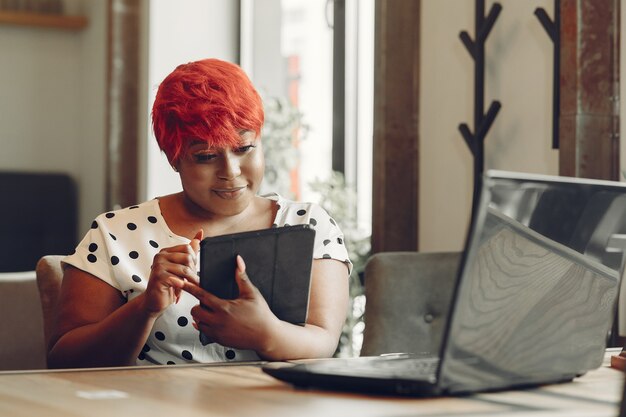 Jeune femme afro-américaine travaillant dans un bureau. Dame dans un chemisier blanc.