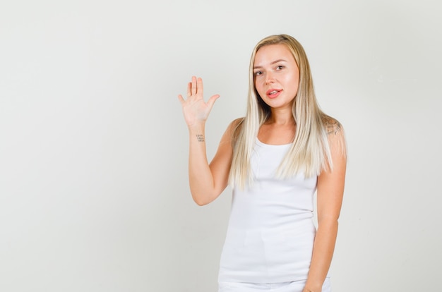 Photo gratuite jeune femme agitant la main et souriant en maillot