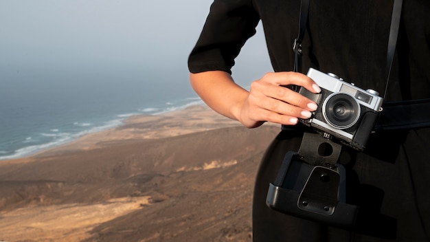 Jeune femme à l'aide d'un appareil photo dans ses vacances