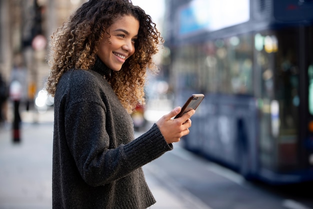 Jeune femme à l'aide de son smartphone dans la ville