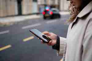 Photo gratuite jeune femme à l'aide de son smartphone dans la ville