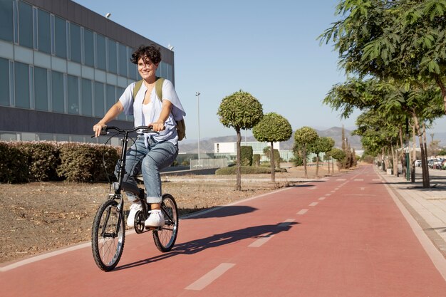 Jeune femme à l'aide de son vélo pliant