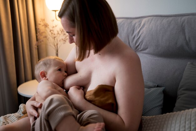 Jeune femme allaitant son bébé mignon