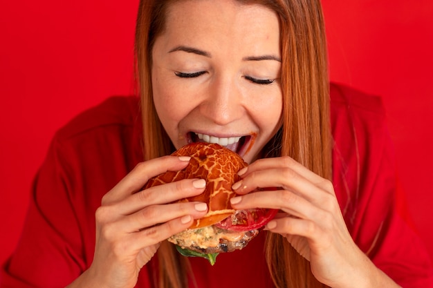 Jeune femme à angle élevé mangeant un hamburger
