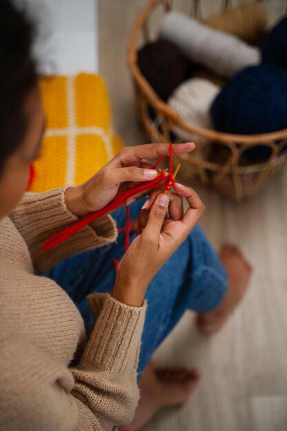 Jeune femme à angle élevé tricotant