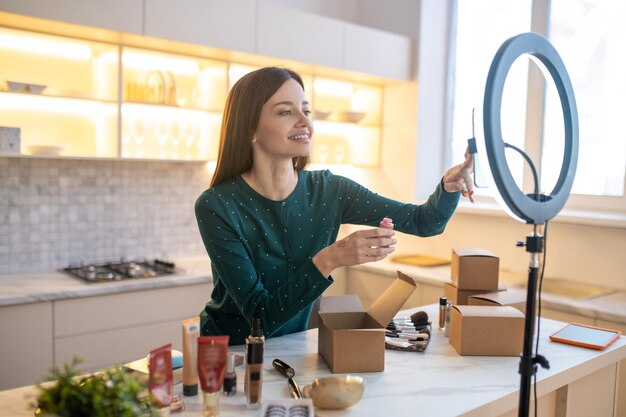 Jeune femme appliquant un échantillon de nouvelle crème tonifiante sur sa main