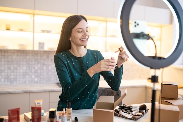 Jeune femme appliquant un échantillon de nouvelle crème tonifiante sur sa main