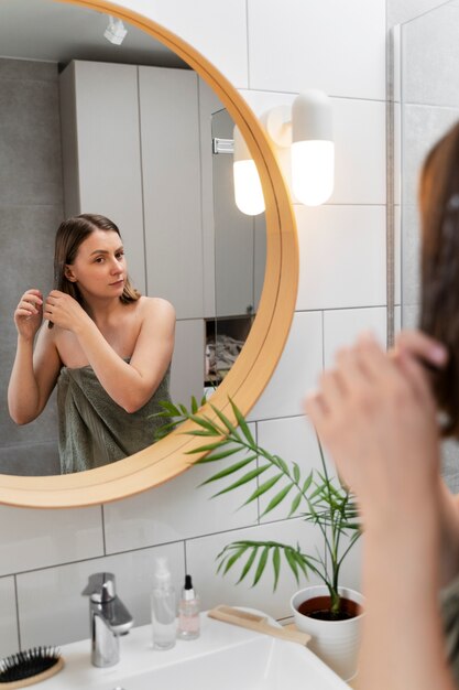 Jeune femme appliquant un produit antipelliculaire