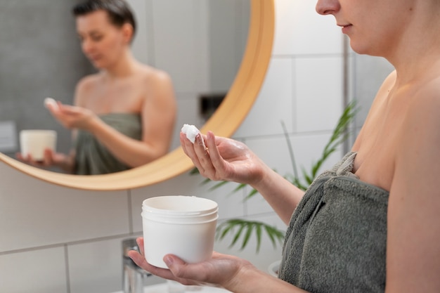 Jeune femme appliquant un produit antipelliculaire