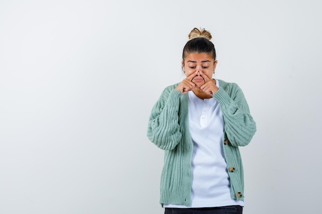 Jeune femme appuyant sur le nez avec les doigts en t-shirt, veste et semblant drôle