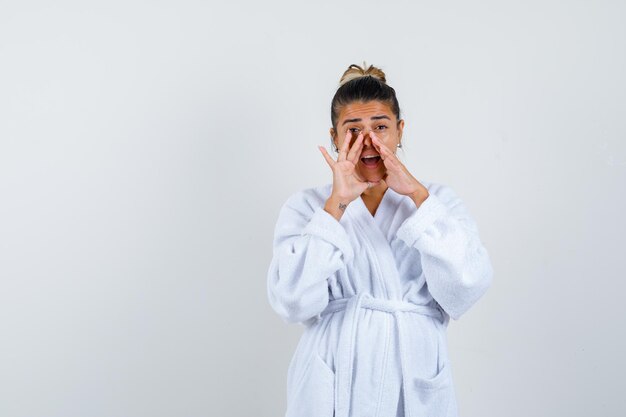 Jeune femme en appuyant sur le nez avec la main en peignoir et à la surprise