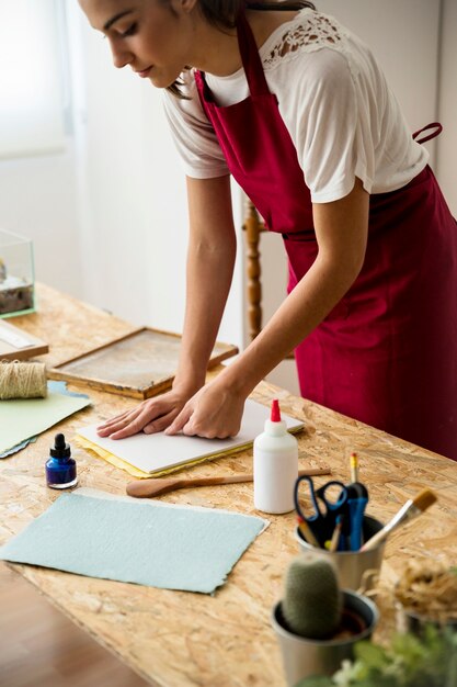 Jeune femme en appuyant sur la pâte à papier dans le moule