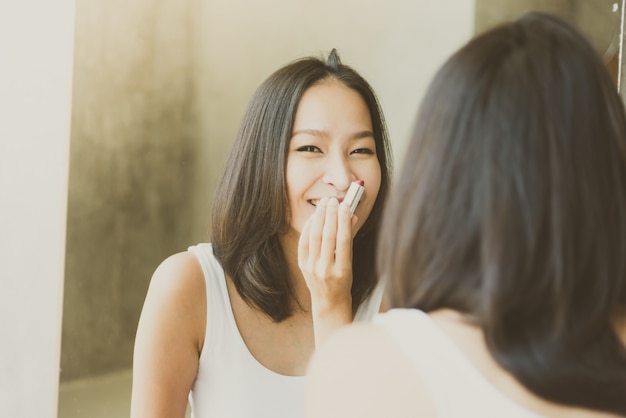 Jeune femme asiatique se maquiller