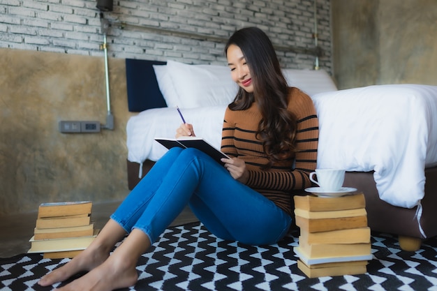 Jeune femme asiatique avec une tasse de café et lire le livre