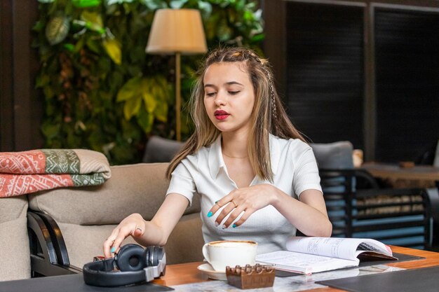 Jeune femme assise au restaurant et prenant ses écouteurs