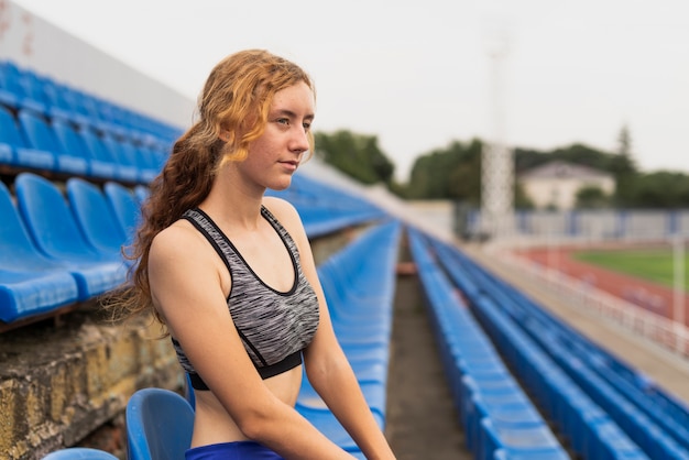 Jeune femme assise au stade