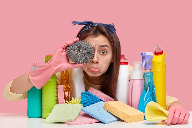 Jeune femme assise à côté de produits de nettoyage