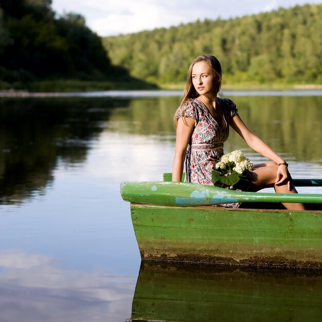 Jeune femme assise dans le bateau sur une journée ensoleillée