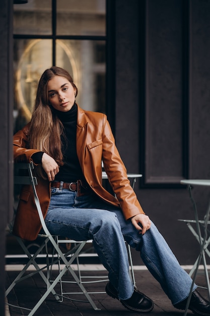 Jeune femme assise à l'extérieur du bar