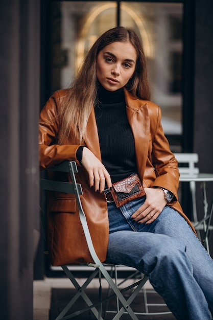 Photo gratuite jeune femme assise à l'extérieur du bar