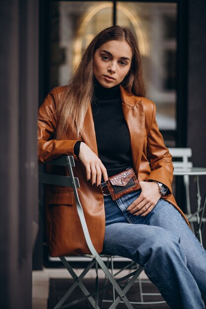 Jeune femme assise à l'extérieur du bar