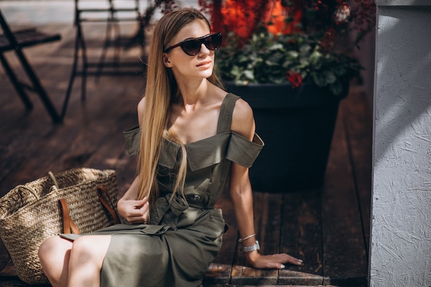 Jeune femme assise à l'extérieur du café