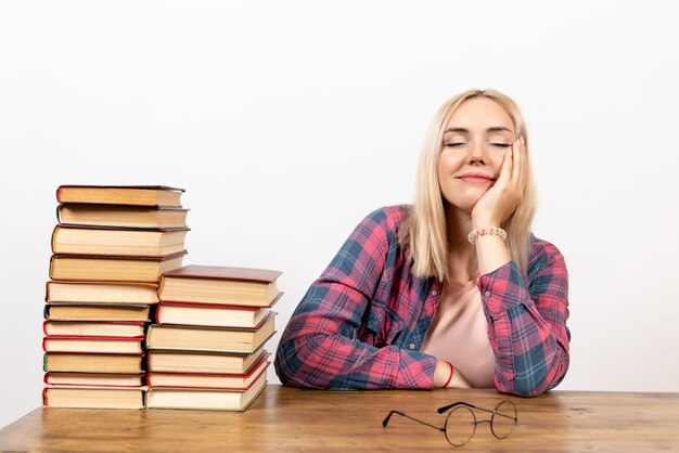 jeune femme assise avec des livres sur blanc