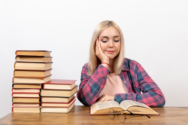 Jeune Femme Assise Avec Des Livres Et Lisant Sur Blanc