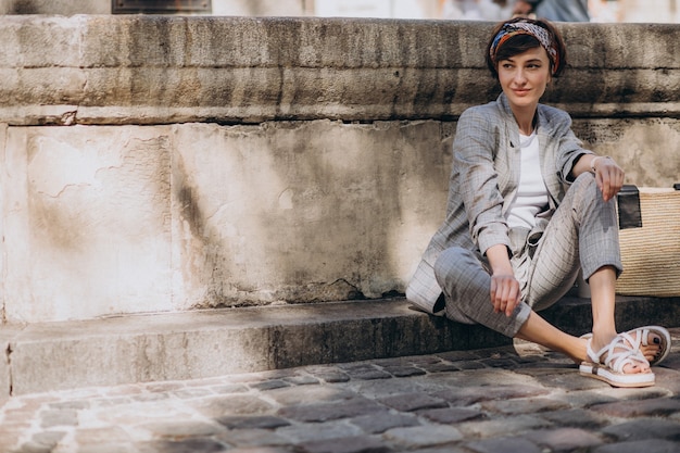 Jeune Femme Assise Près De La Fontaine