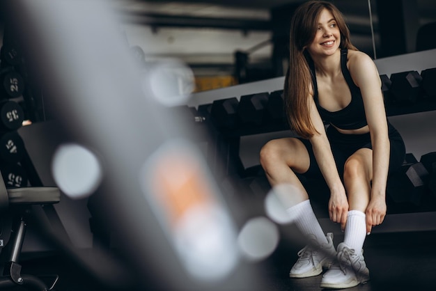 Jeune femme assise à la salle de gym