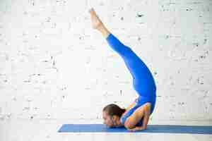 Photo gratuite jeune femme attirante à ganda bherundasana pose, studio blanc