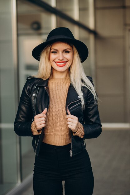 Jeune femme au chapeau noir marchant à l'extérieur de la rue