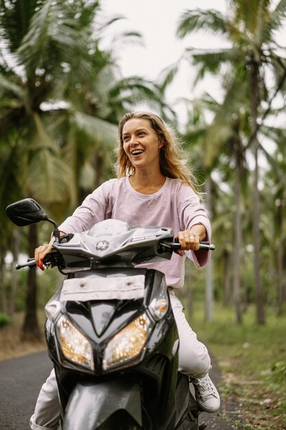 jeune femme au volant d'un cyclomoteur vie tropicale