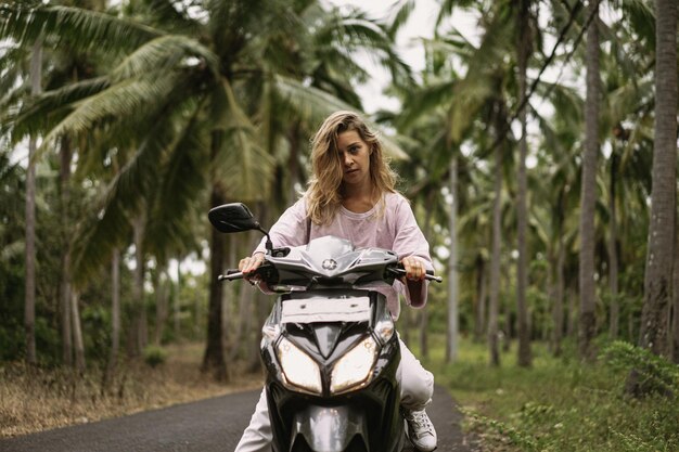 jeune femme au volant d'un cyclomoteur vie tropicale