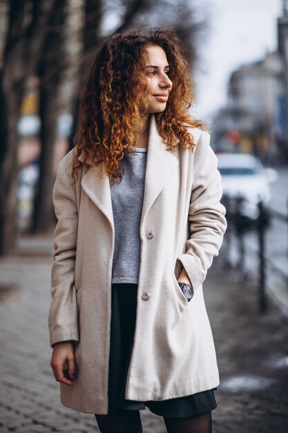 Jeune femme aux cheveux bouclés en dehors de la rue