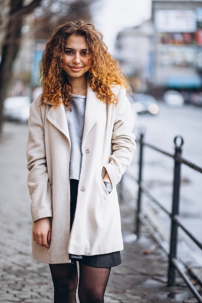 Jeune femme aux cheveux bouclés en dehors de la rue