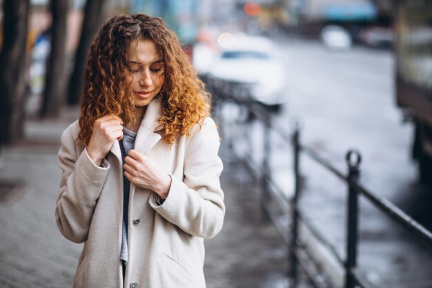 Jeune femme aux cheveux bouclés en dehors de la rue