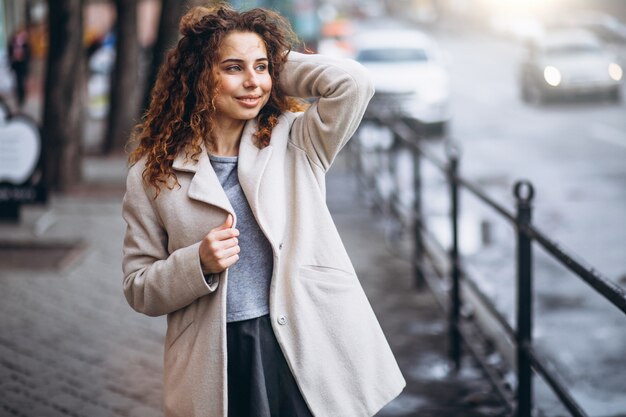 Jeune femme aux cheveux bouclés en dehors de la rue