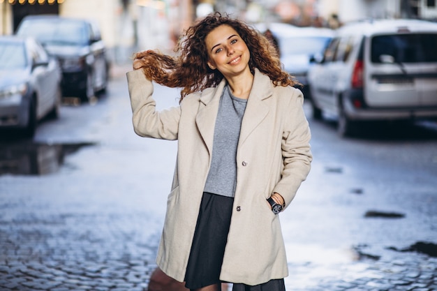 Photo gratuite jeune femme aux cheveux bouclés en dehors de la rue