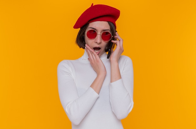 Jeune femme aux cheveux courts en col roulé blanc portant béret