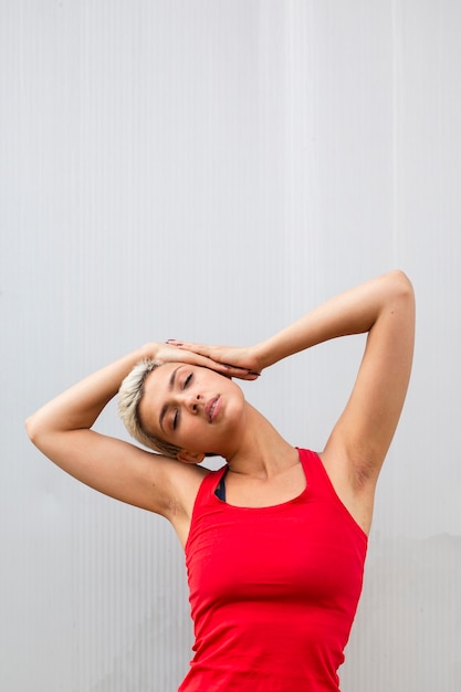 Jeune femme aux cheveux courts qui s'étend à l'extérieur