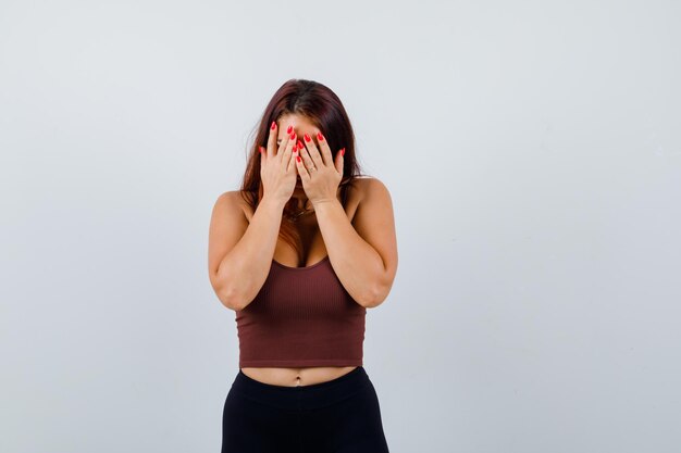 Jeune femme aux cheveux longs dans un haut court marron