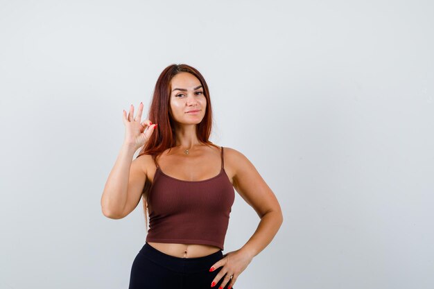 Jeune femme aux cheveux longs dans un haut court marron